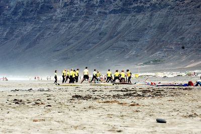 People enjoying on beach against sky