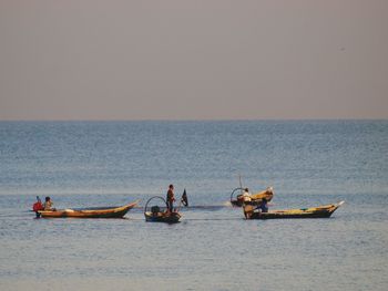 People enjoying in sea against clear sky