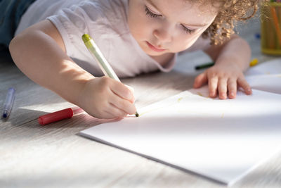 Cute girl drawing on book