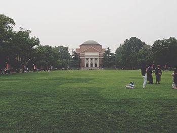 People in front of building with trees in background