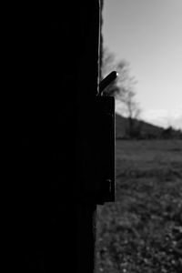 Close-up of silhouette metal structure on field against sky