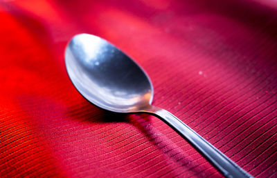 High angle view of spoon on red textile
