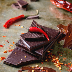 High angle view of red chili peppers and chocolates on table