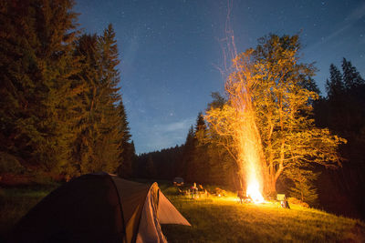 Illuminated tent against sky at night