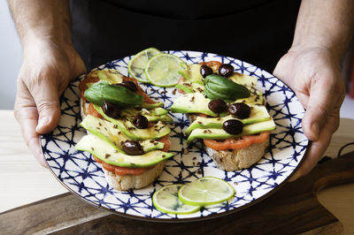 Midsection of man holding food in plate on table