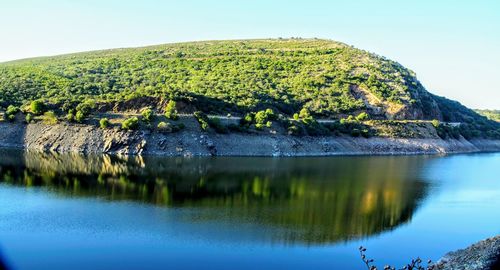 Scenic view of lake by mountains against clear sky