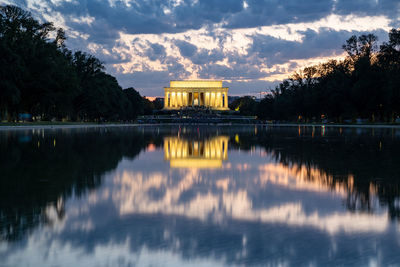 Reflection of building in lake at sunset