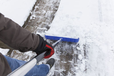 Low section of man standing on snow