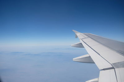 Cropped airplane flying over blue sky