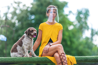 Woman with dog sitting outdoors