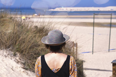 Rear view of woman standing against sky