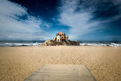 Scenic view of beach by sea against sky