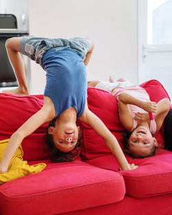 Portrait of friends lying on sofa at home