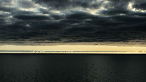 Scenic view of sea against storm clouds