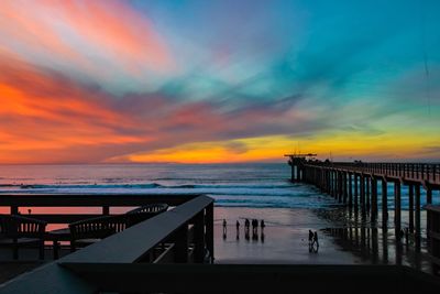 Pier over sea against sky during sunset