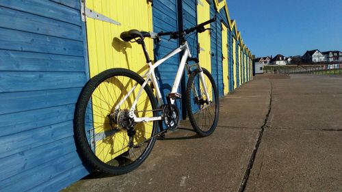 Bicycle parked against yellow wall