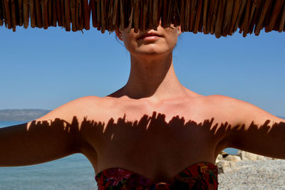 Midsection of mid adult woman at beach