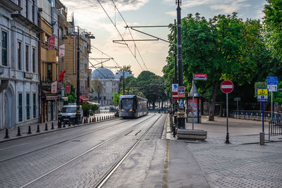 Railroad tracks amidst buildings in city against sky