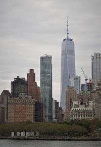 Buildings in city against cloudy sky
