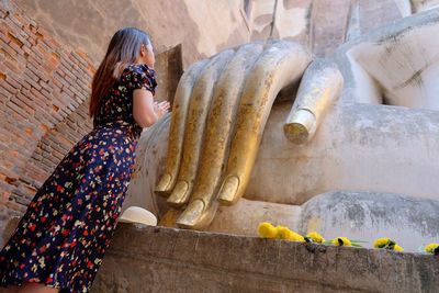 Low angle view of woman praying in temple