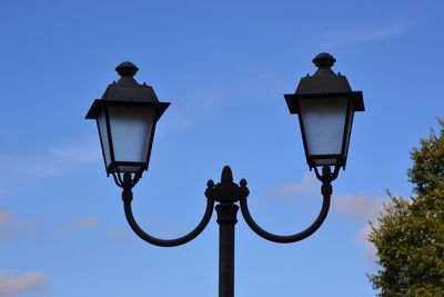 Low angle view of street light against blue sky