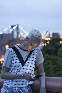 Young woman looking at illuminated city