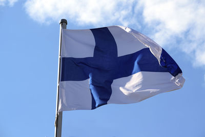 Low angle view of finnish flag against blue sky