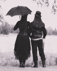 Rear view of people walking on field