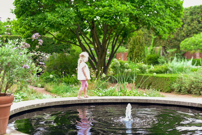 Girl standing by pond