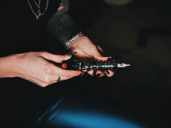 Midsection of woman holding machinery