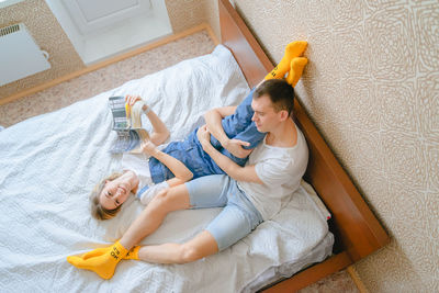 Mother and daughter sitting on bed at home