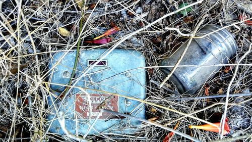 Close-up of abandoned fuse box and jar on field