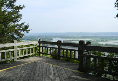 Wooden bridge over sea against sky