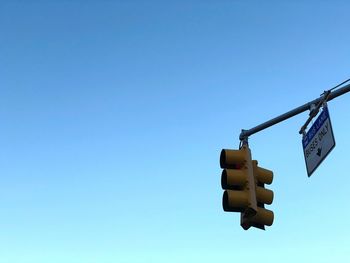 Low angle view of stoplight against clear blue sky