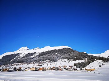 Scenic view of snowcapped mountains against clear blue sky