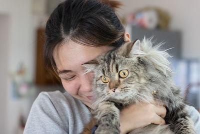 Close-up of woman with cat at home