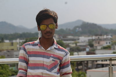Man standing on building terrace against sky