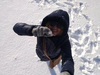 Portrait of smiling young woman standing on snow