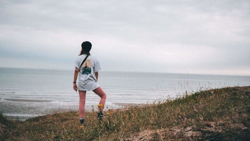 Rear view of person on beach against sky