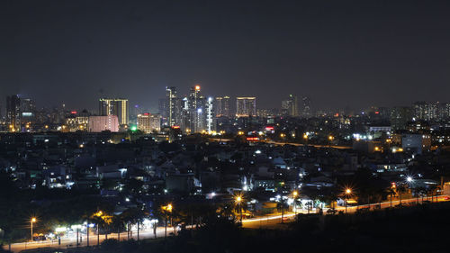 High angle view of illuminated buildings against sky at night