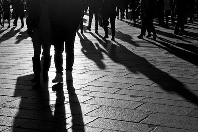 Low section of people walking on footpath in city