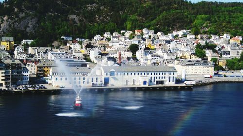 Boats in sea against buildings in city