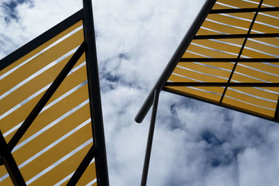 View from below of colourful structures against the sky