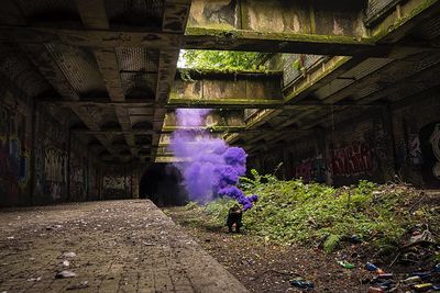 Man with distress flare at abandoned building