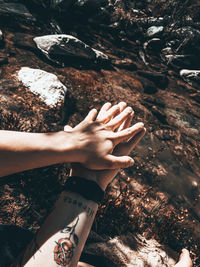 High angle view of woman hand on rock