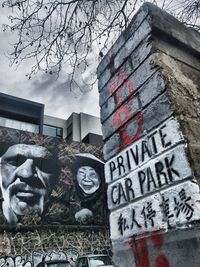 Low angle view of graffiti on building against sky