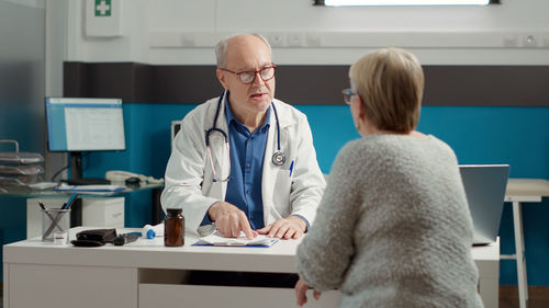Senior doctor talking with patient at clinic