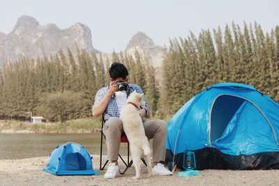 Men sitting in tent on land against sky