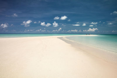 Scenic view of white clear sand and turqoise water beach against sky on gusung island derawan