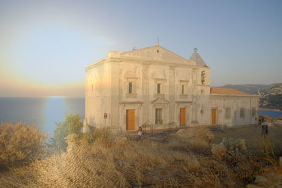 Historic building by sea against sky